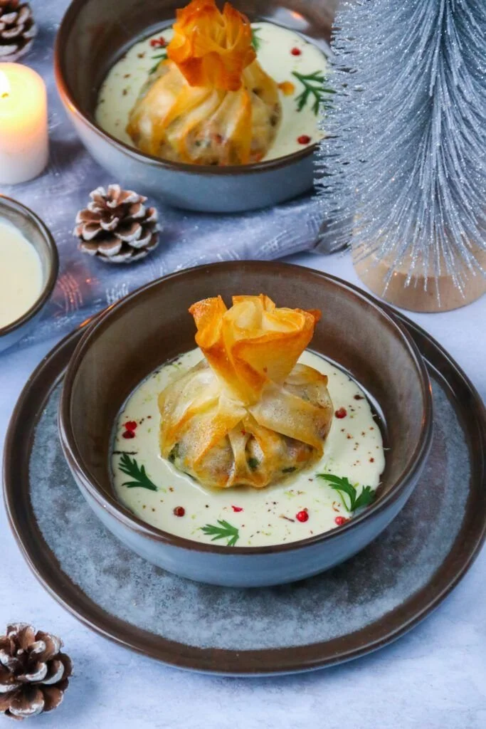 Aumônières de loup de mer accompagnées de légumes et sauce prosecco