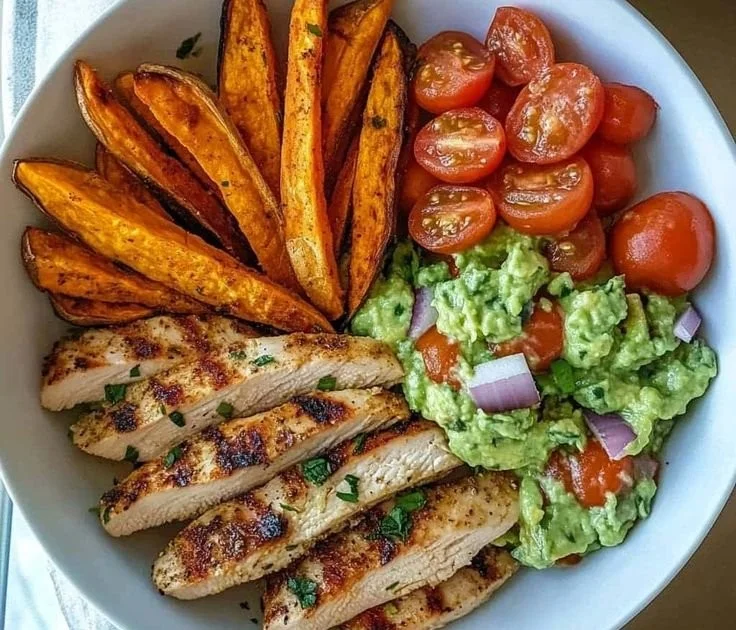 Bol de poulet grillé aux herbes avec frites de patate douce et salsa d'avocat